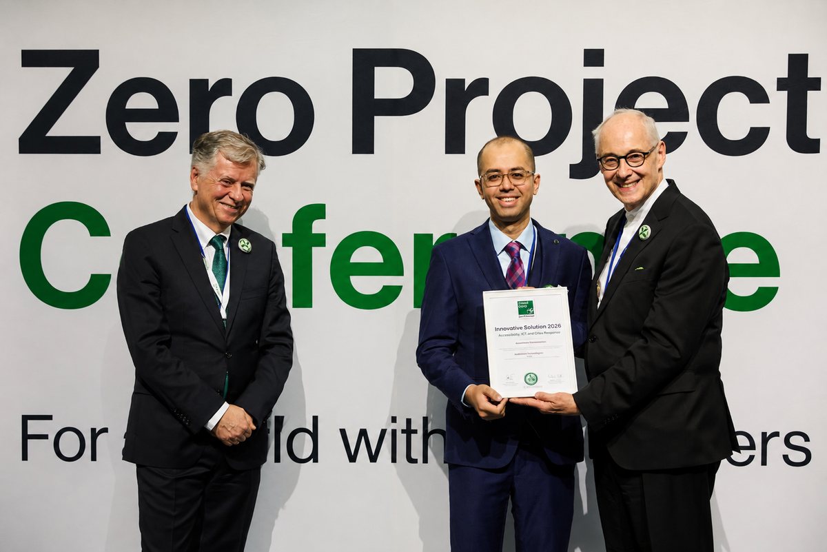 Audivision’s founder receiving the framed Innovative Solution 2026 certificate from two Zero Project representatives, in front of the Zero Project Conference backdrop reading “For a world with zero barriers”.